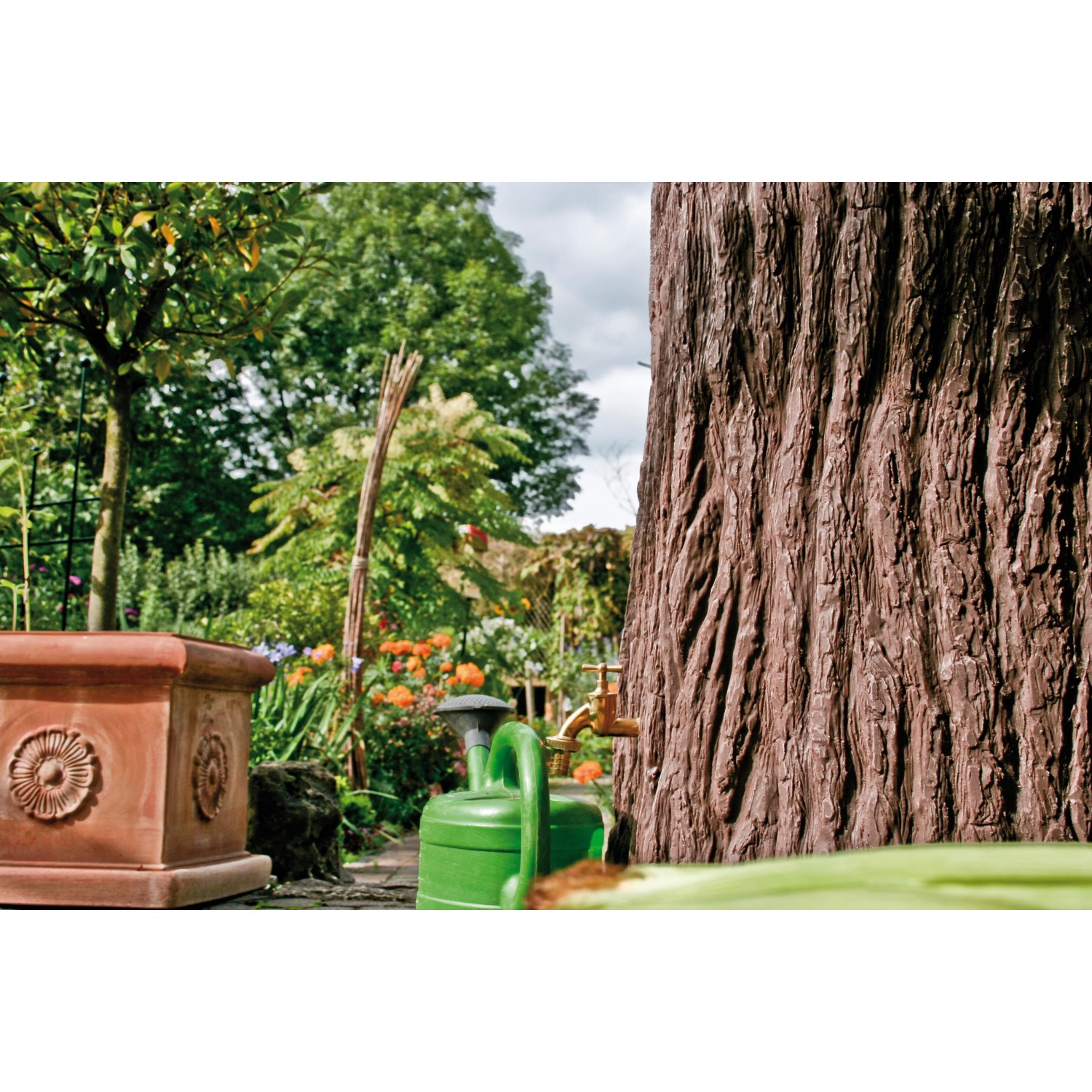 Arves Regentonne Evergreen 475 l Dunkelbraun im Garten mit Zapfhahn und Gießkanne.