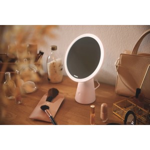 Pinke Philips Tischleuchte Mirror mit Spiegel auf einem Tisch mit Kosmetikartikeln.