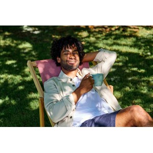 Mann entspannt mit Mepal Silueta Henkelbecher in Vivid Mauve im Garten.