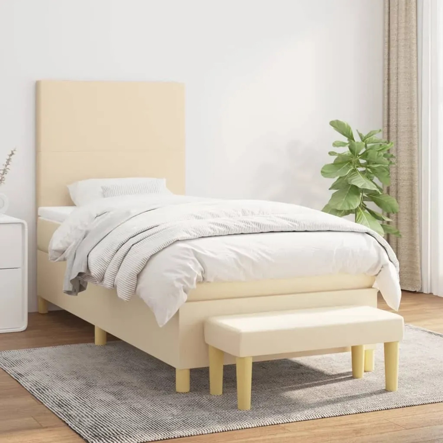 Cremefarbenes Boxspringbett (90x190 cm) mit Matratze, Kopfteil und Bank. Stoffbezug.