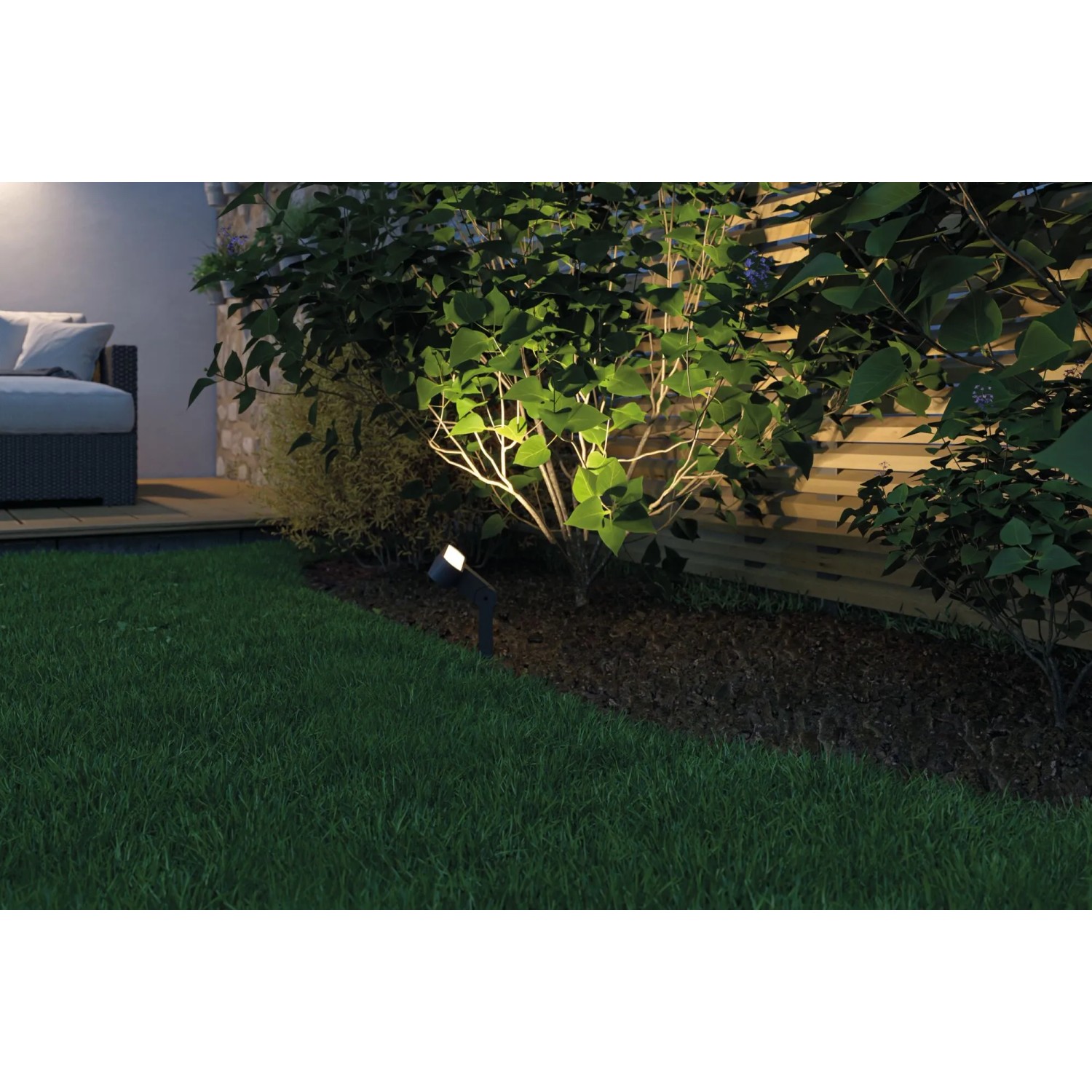 Paulmann LED-Gartenstrahler Ito, anthrazit, beleuchtet einen Busch im Garten. Teil des Plug & Shine Systems.