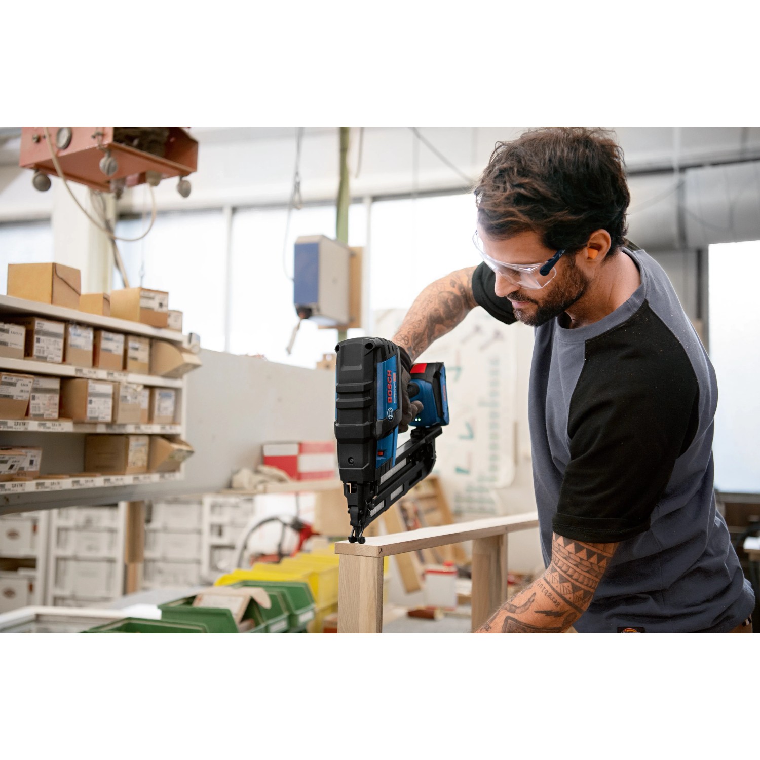 Bosch Professional Akku-Holznagler GNH 18V-64 M in Aktion beim Nageln von Holz.