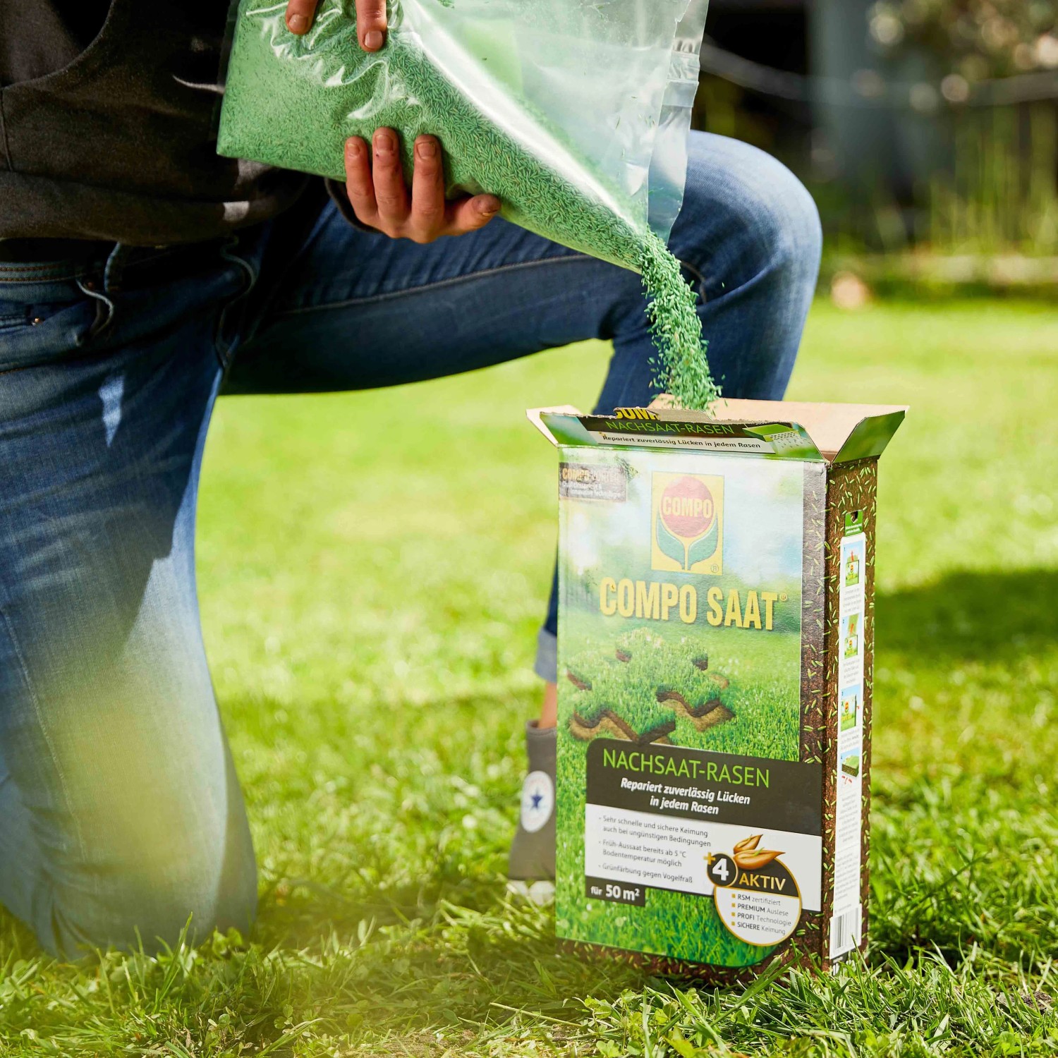Compo Saat Rasen-Nachsaat: Person schüttet Rasensamen auf eine Packung im Garten.