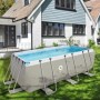 Rechteckiger Avenli Stahlrahmenpool, grau, im Garten vor einem Haus.