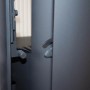 Detailaufnahme des Justus Kaminofen Mino Trios 2.0 in Schwarz, Fokus auf Verschlussmechanismus.