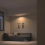 Philips Hue Milliskin LED-Einbauspot in Aluminium, rund, spendet warmweißes Licht im Wohnzimmer.
