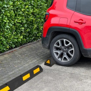 UvV Ecopark Radstopper in Schwarz-Gelb vor einem roten Auto auf einem Parkplatz.
