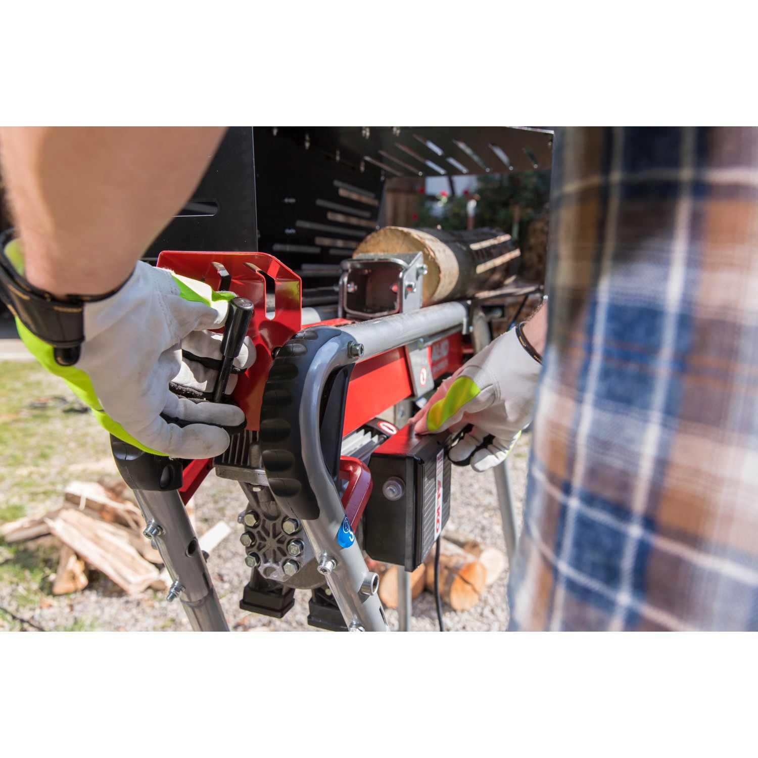 Al-Ko Elektroholzspalter LSH 520/5 in Nutzung: Holzspalter mit Holzstück und Bediener mit Handschuhen.