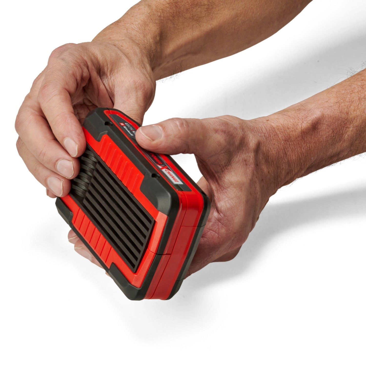 Einhell Power X-Change Akku 18V/4,0 Ah in Händen, rot-schwarz. Akku für Elektrowerkzeuge.