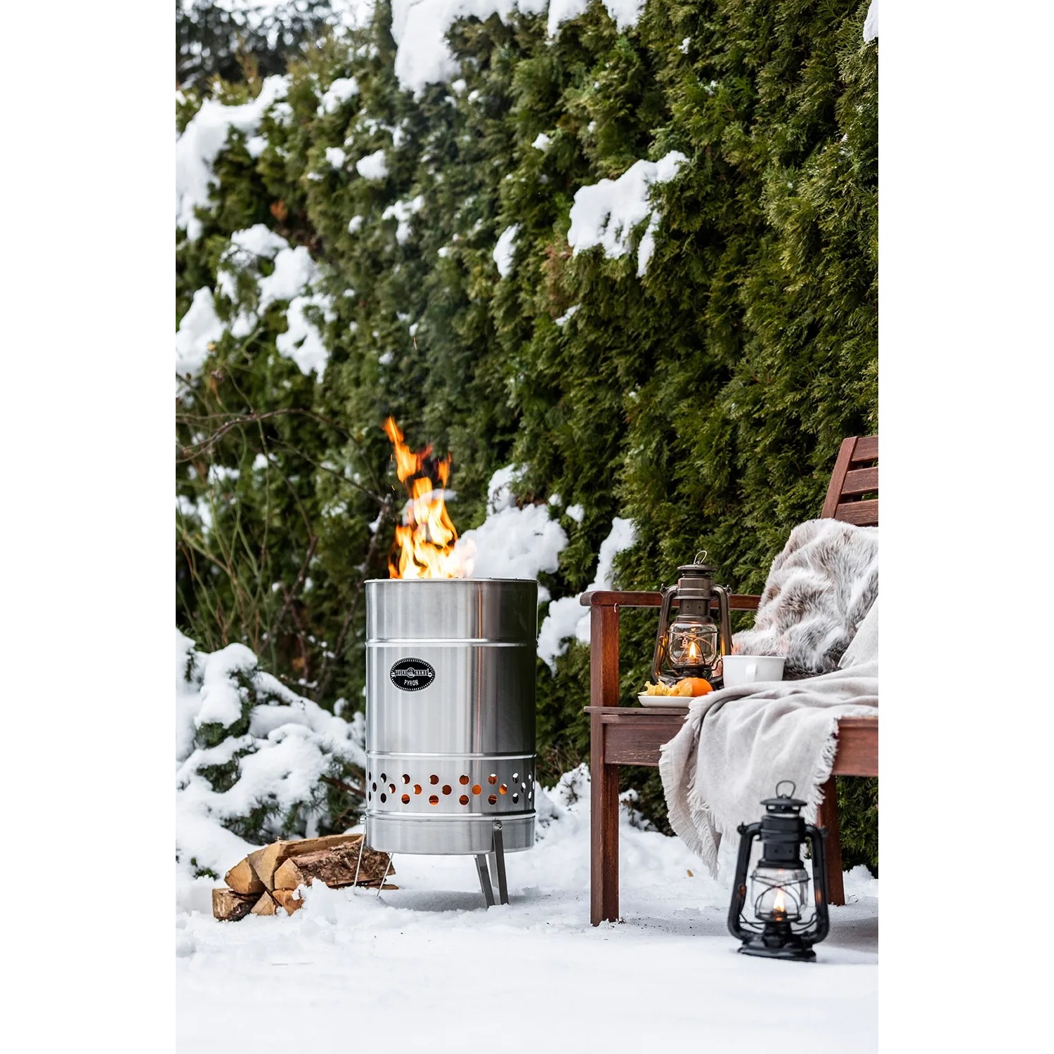 Feuerhand Pyron Feuertonne aus Edelstahl (25 l) im Garten mit brennendem Feuer und Holzscheiten.