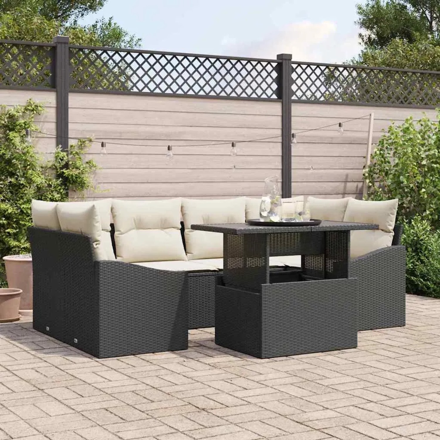Schwarzes 7-teiliges vidaXL Garten-Sofa-Set aus Poly Rattan mit Tisch und cremefarbenen Kissen.