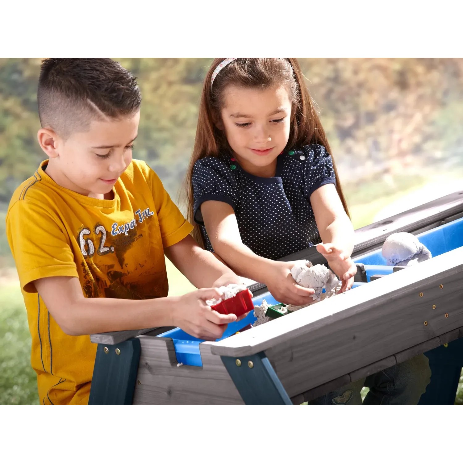 Axi Sand- und Wasser-Picknicktisch Nick grau/blau mit spielenden Kindern.