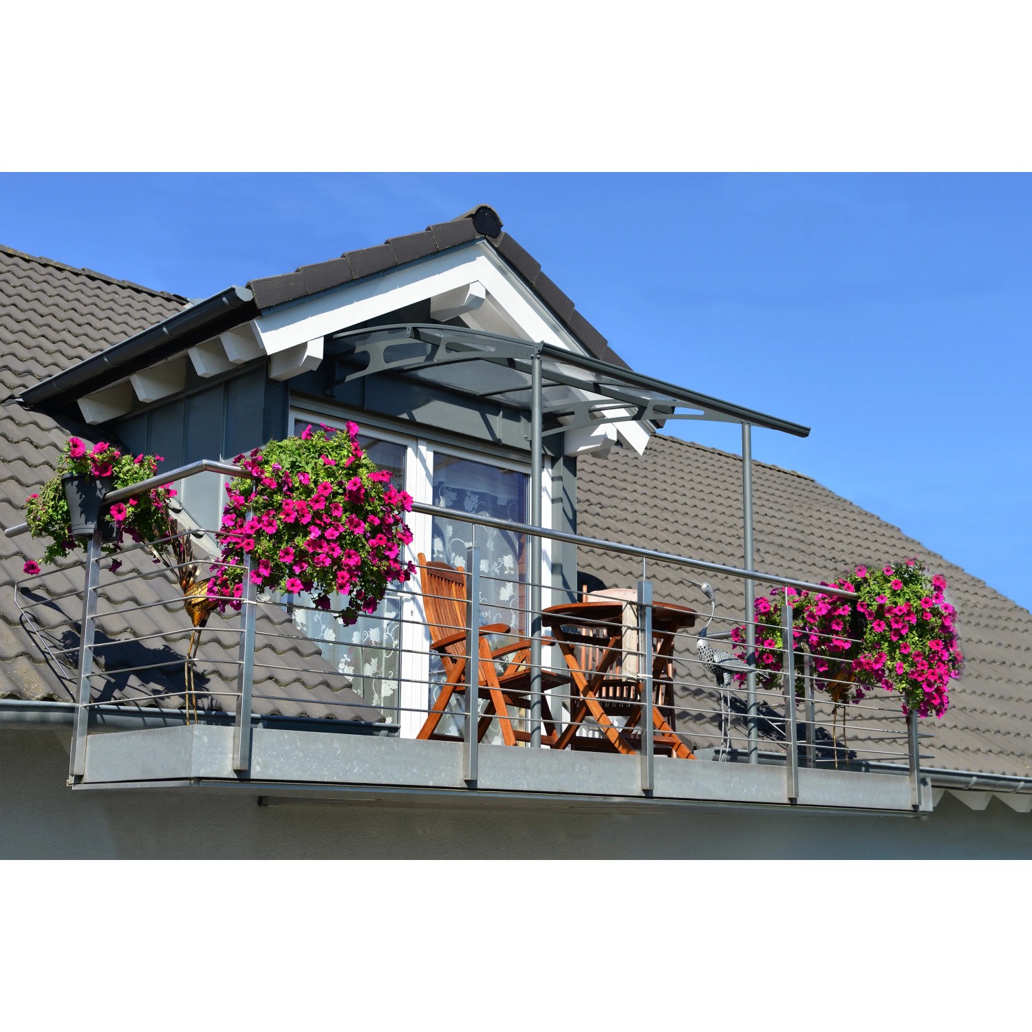 Graues Palram-Canopia Vordach Vega 2x2 über Balkon mit Tisch und Stühlen.