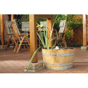 Filtral UVC 1500 Teichpumpe im Holzfass mit Wasserpflanzen und kleinem Springbrunnen.