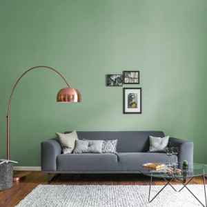 Wohnzimmer mit Wandfarbe Alpina Feine Farben Hüterin der Freiheit® Patinagrün, Sofa und Lampe.