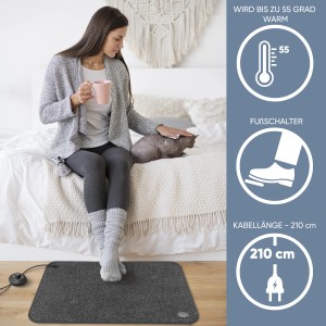 Björn&Schiller Heizteppich 40x60 mit Fußschalter im Wohnzimmer mit Frau und Katze.