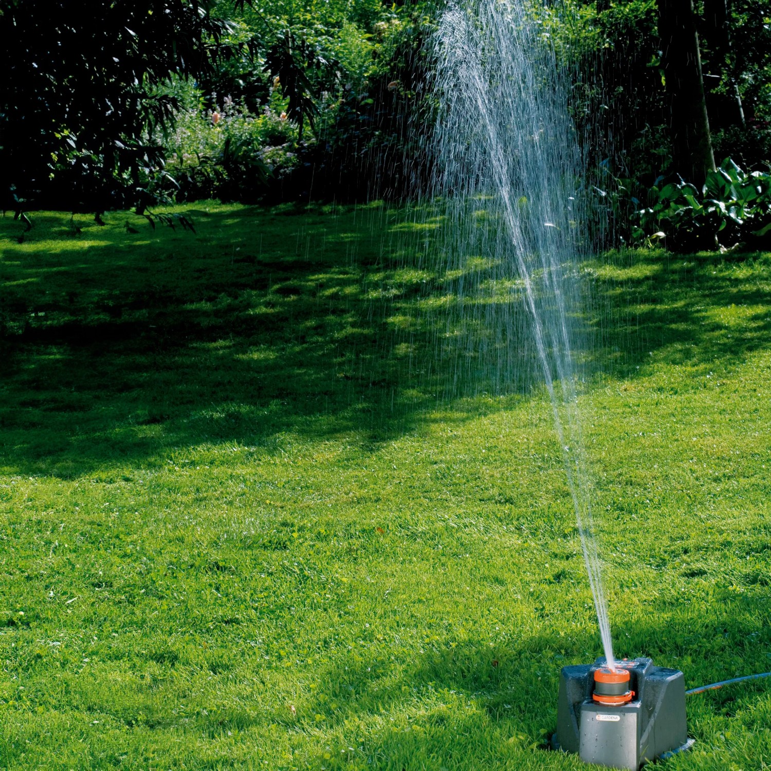 Gardena Comfort Vielflächenregner AquaContour im Einsatz auf Rasenfläche. Regner bewässert den Garten.