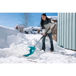 Frau schiebt Schnee mit dem Gardena combisystem Schneeschieber KST 40 cm.