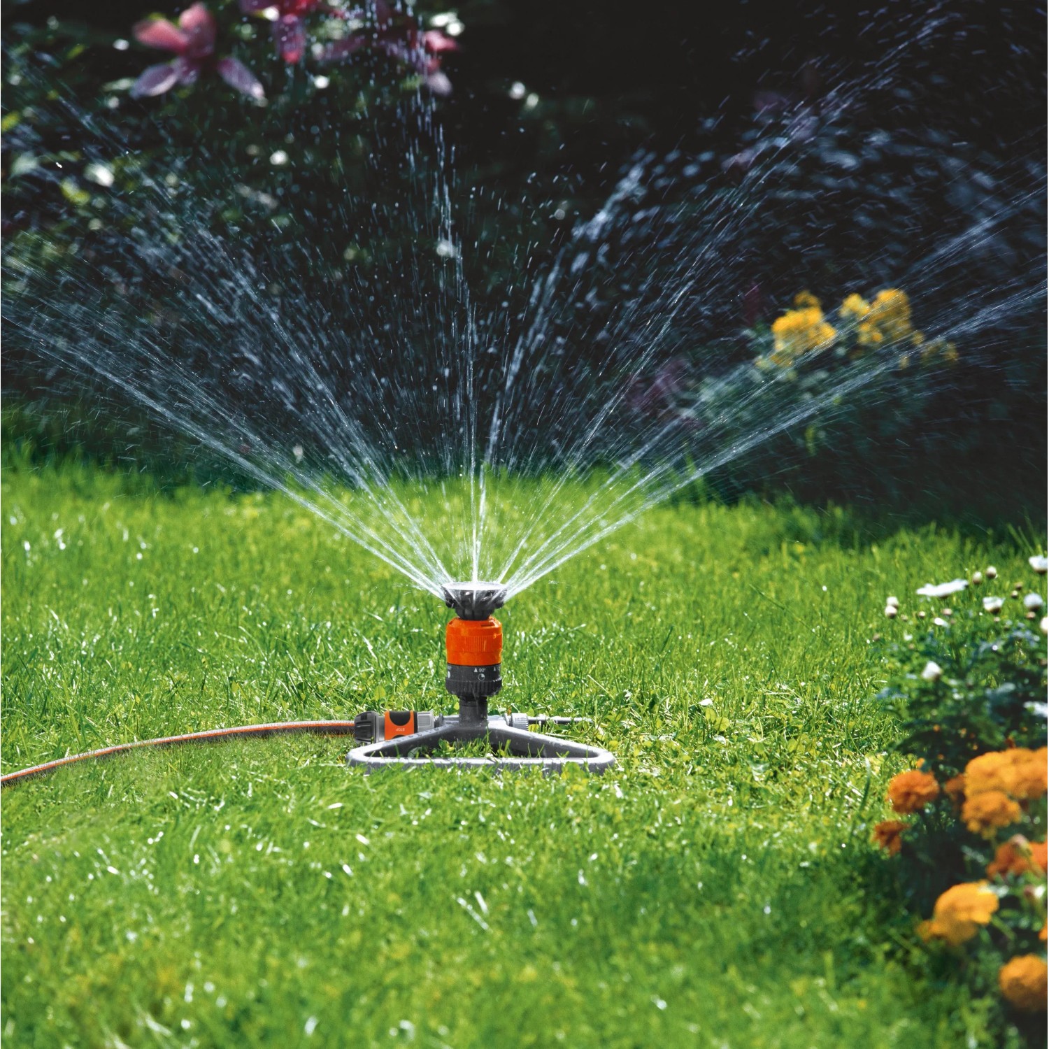 Gardena Comfort Kreisregner Vario auf Schlitten beim Bewässern eines Gartens.