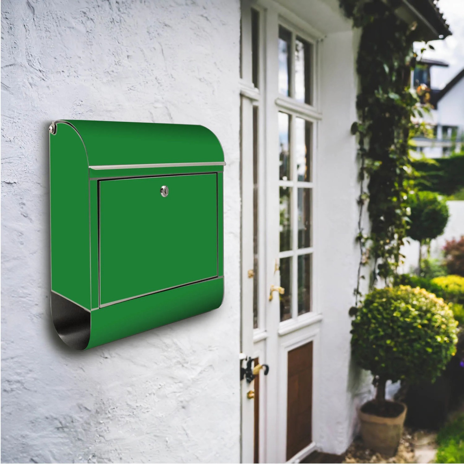 Edelstahl Briefkasten mit Zeitungsfach und grünem Motiv an einer weißen Hauswand.