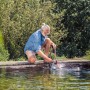 Mann nutzt Gardena Schmutzwasser-Tauchpumpe 9000 zum Abpumpen eines Teichs.