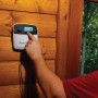 Rain Bird Steuergerät (6 Zonen) in Weiß-Schwarz, montiert an Holzwand, wird bedient.