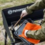 Petromax Aramid Topflappen Paar in Orange-Schwarz beim Kochen am Grill.