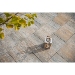 Großformatige Diephaus Alira Terrassenplatten in Muschelkalk-Optik, verlegt im Garten mit Laterne. Ideal für Terrasse & Gehweg.