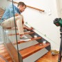 Bosch UniversalLevel 360 Kreuzlinienlaser im Einsatz auf Stativ, projiziert grüne Laserlinie an Treppe.