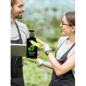 Pflanzwerk Bio-Booster Flüssigdünger 1L, präsentiert von zwei Personen im Garten.