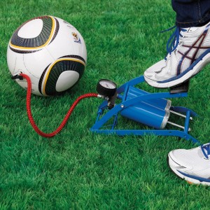 Fußluftpumpe Doppelzylinder beim Aufpumpen eines Balls auf Rasen.