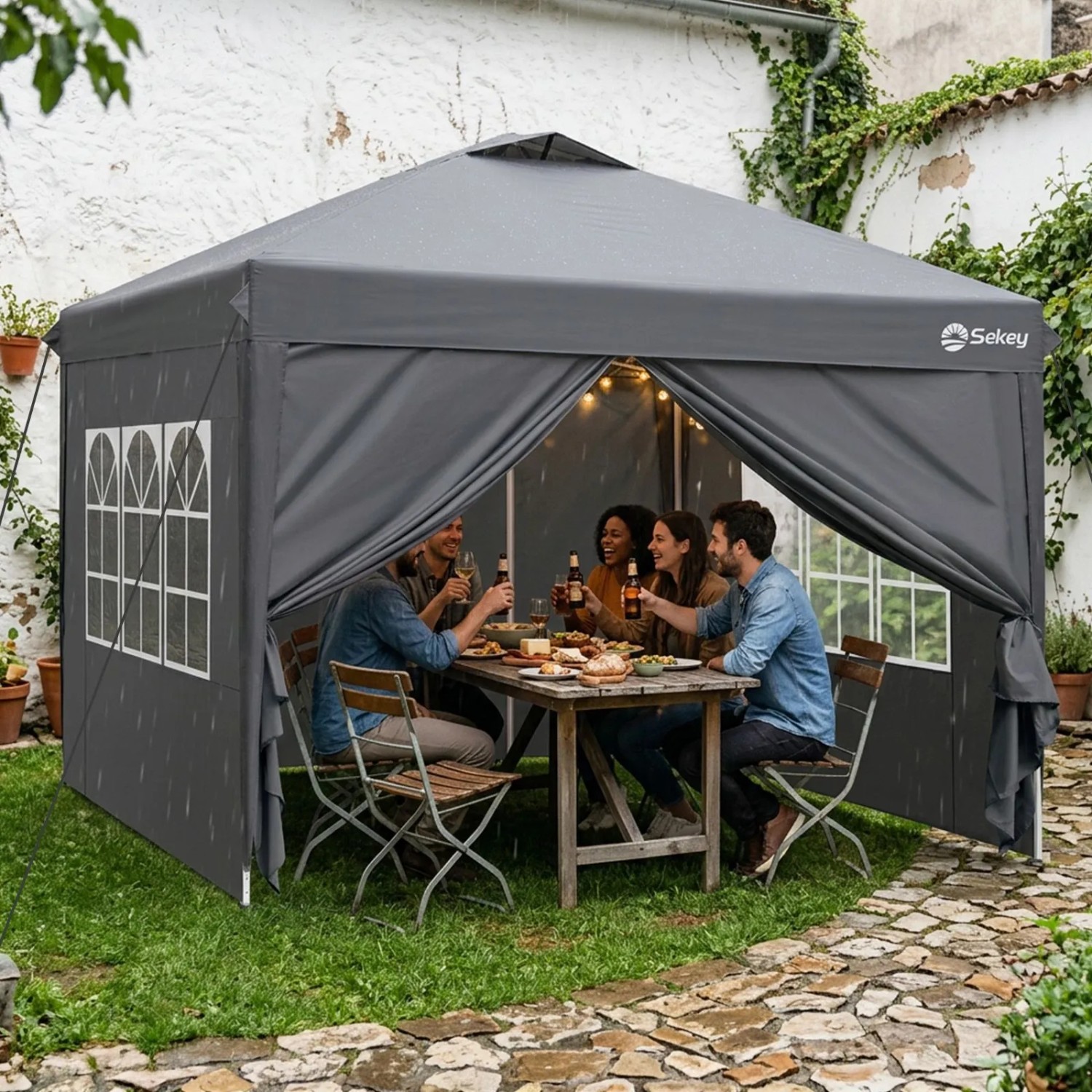 Grauer Sekey Faltpavillon 3x3m mit Seitenteilen im Garten. Wasserdichtes Pop Up Partyzelt schützt Gäste bei Feier im Freien.