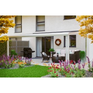 Weiße Terrassenüberdachung Genua aus Aluminium mit Polycarbonat-Dach auf Terrasse mit Gartenmöbeln.