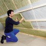 Mann verlegt Rockwool Formrock Untersparrendämmung (60mm) zwischen Holzsparren.