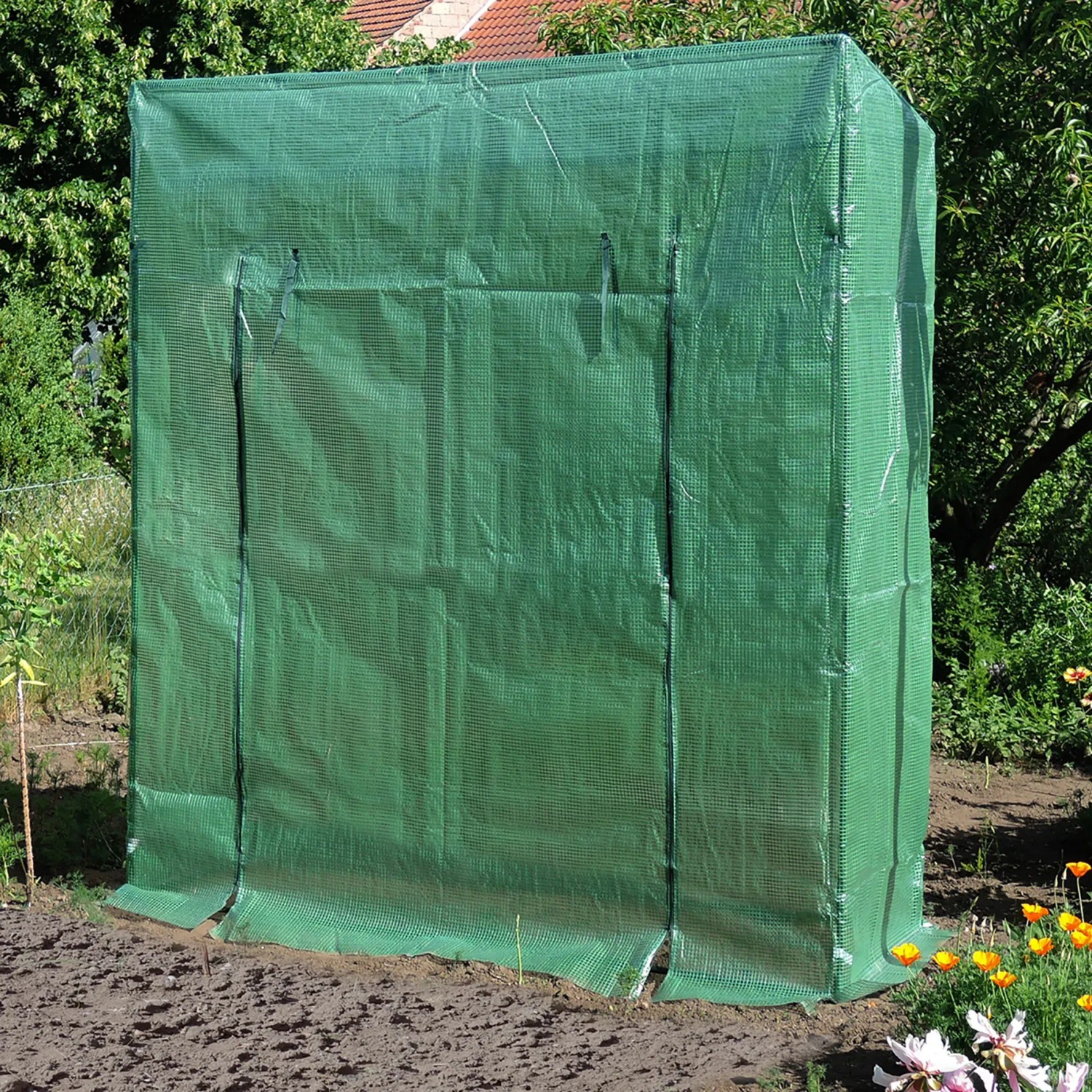 Grünes Foliengewächshaus 1,17 m² im Garten, ideal für Pflanzen, Kräuter und Gemüse.
