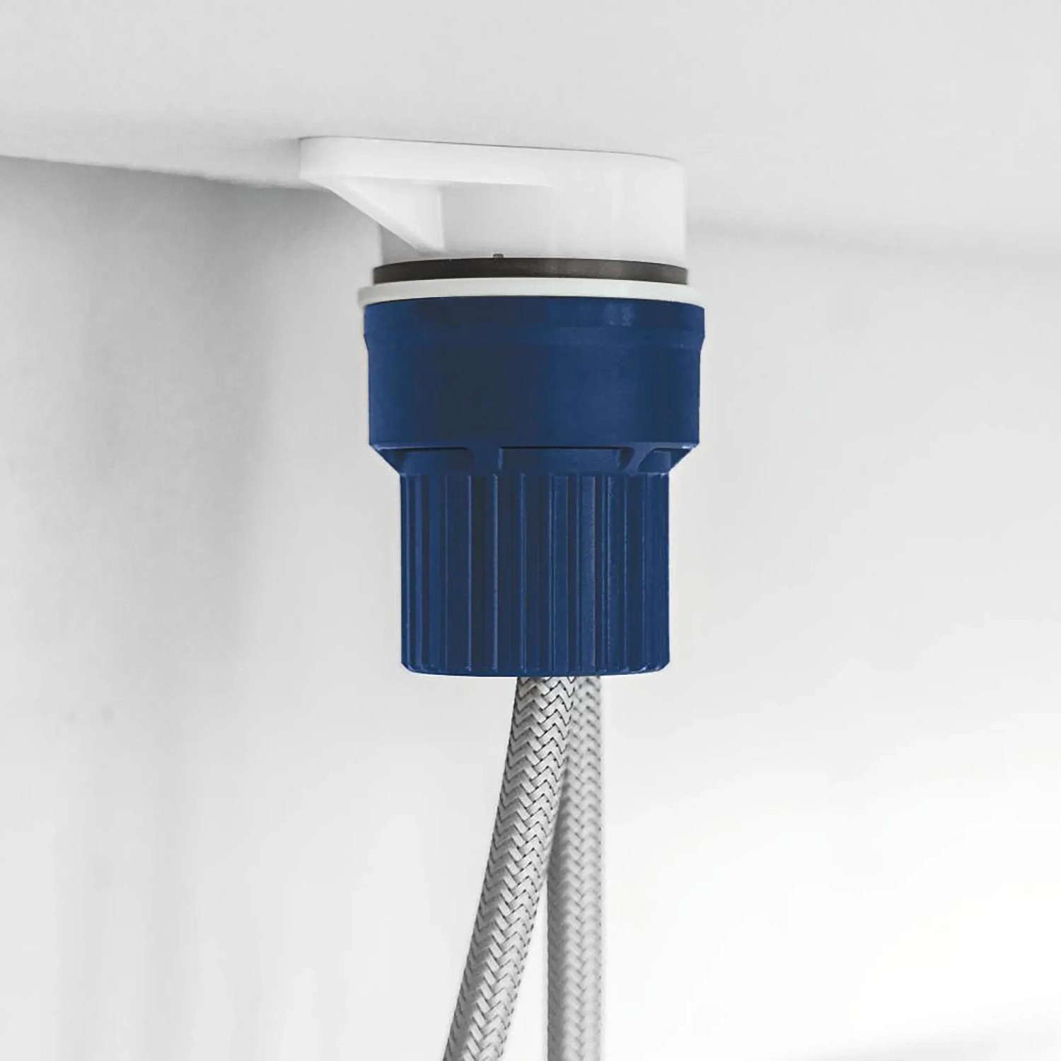 Detailaufnahme der Grohe QuickFix Küchenarmatur Montage mit blauer Halterung und flexiblen Schläuchen.