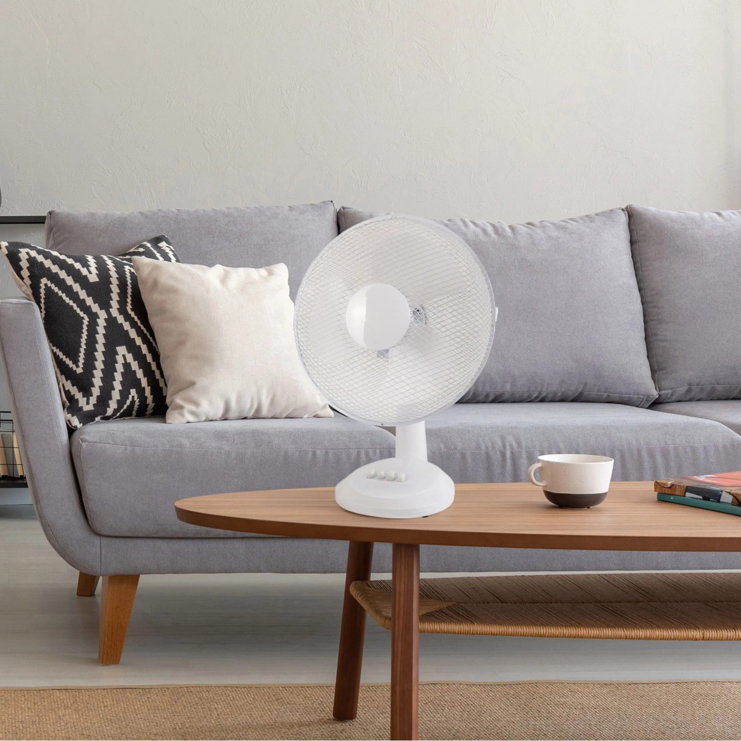 Weißer CMI Tischventilator (Ø 30 cm) auf Tisch vor Couch. Ventilator für frische Luft.