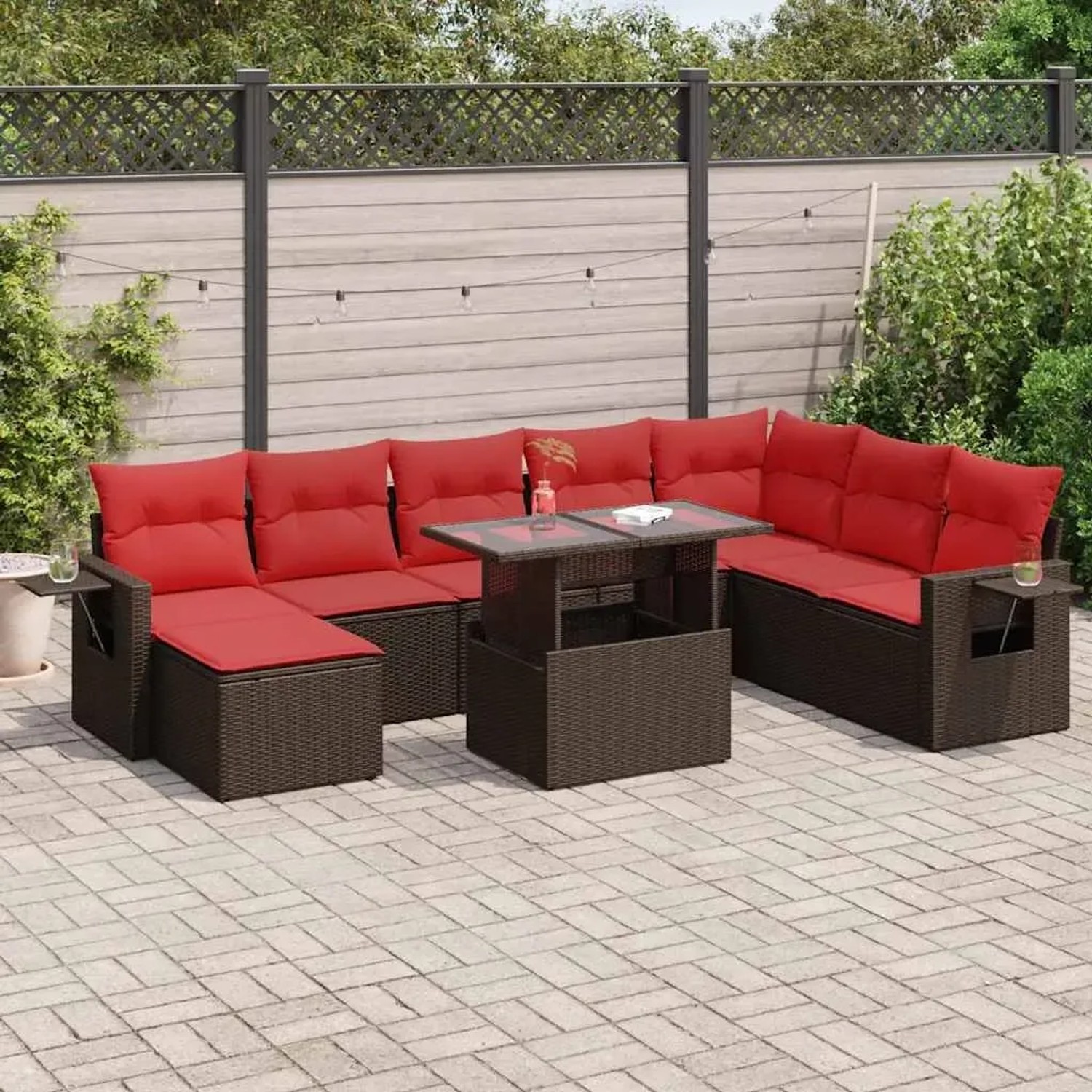Braune 9-teilige Garten-Sofagarnitur aus Poly Rattan mit roten Kissen und Tisch mit Glasplatte.