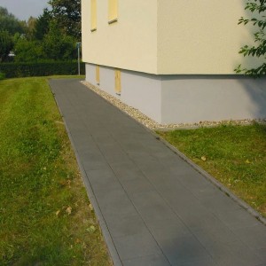 Anthrazit Gehwegplatten (40x40x5 cm) mit Fase als Gartenweg neben Haus.