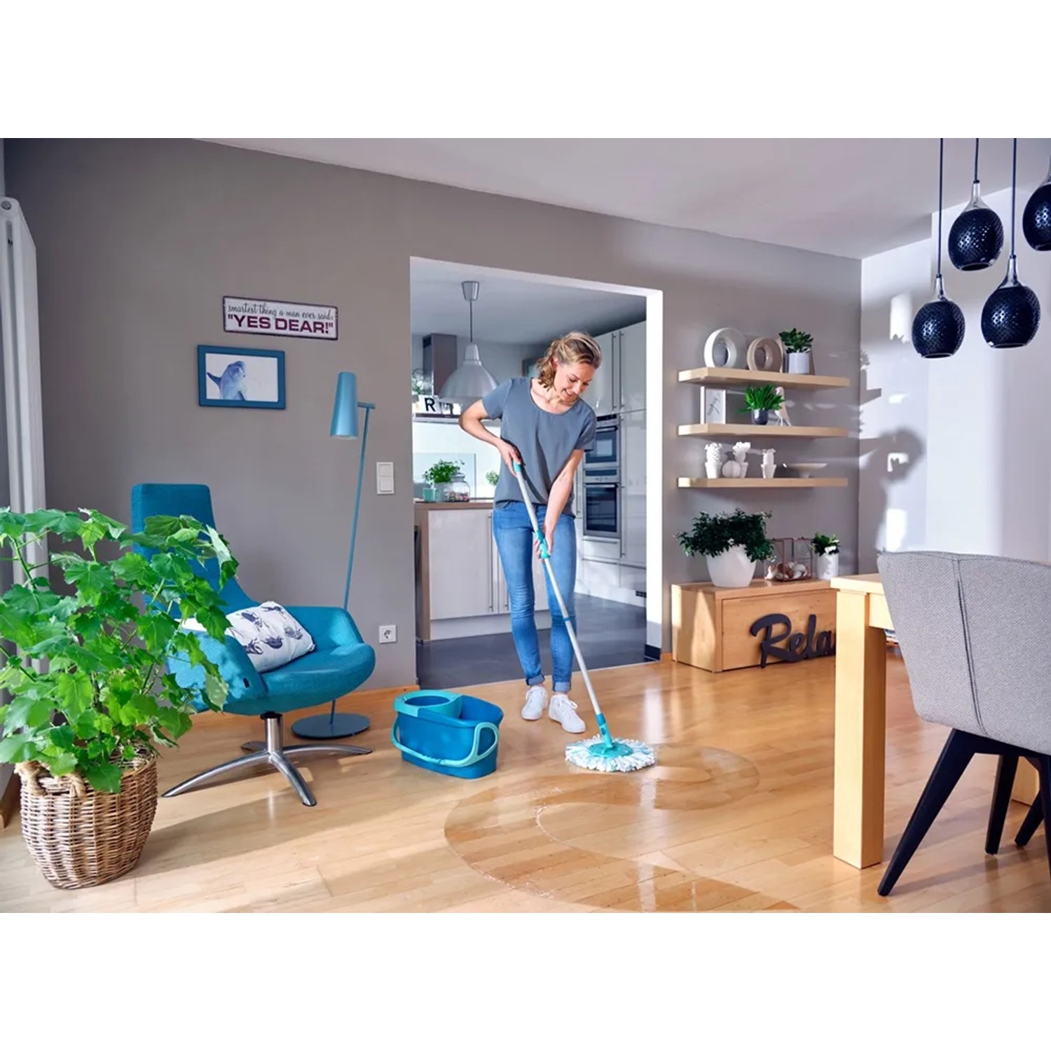 Frau wischt Holzboden mit Leifheit Clean Twist Disc Mop Ergo Reinigungsgerät und Eimer.
