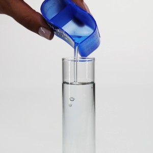 Zugabe von JBL pH-/KH-Plus Aquarium-Wasseraufbereiter in ein Reagenzglas.