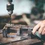 Metallbohrer bohrt in Werkstück, eingespannt in Schraubstock. KLASEBO Spiralbohrer Zubehör.