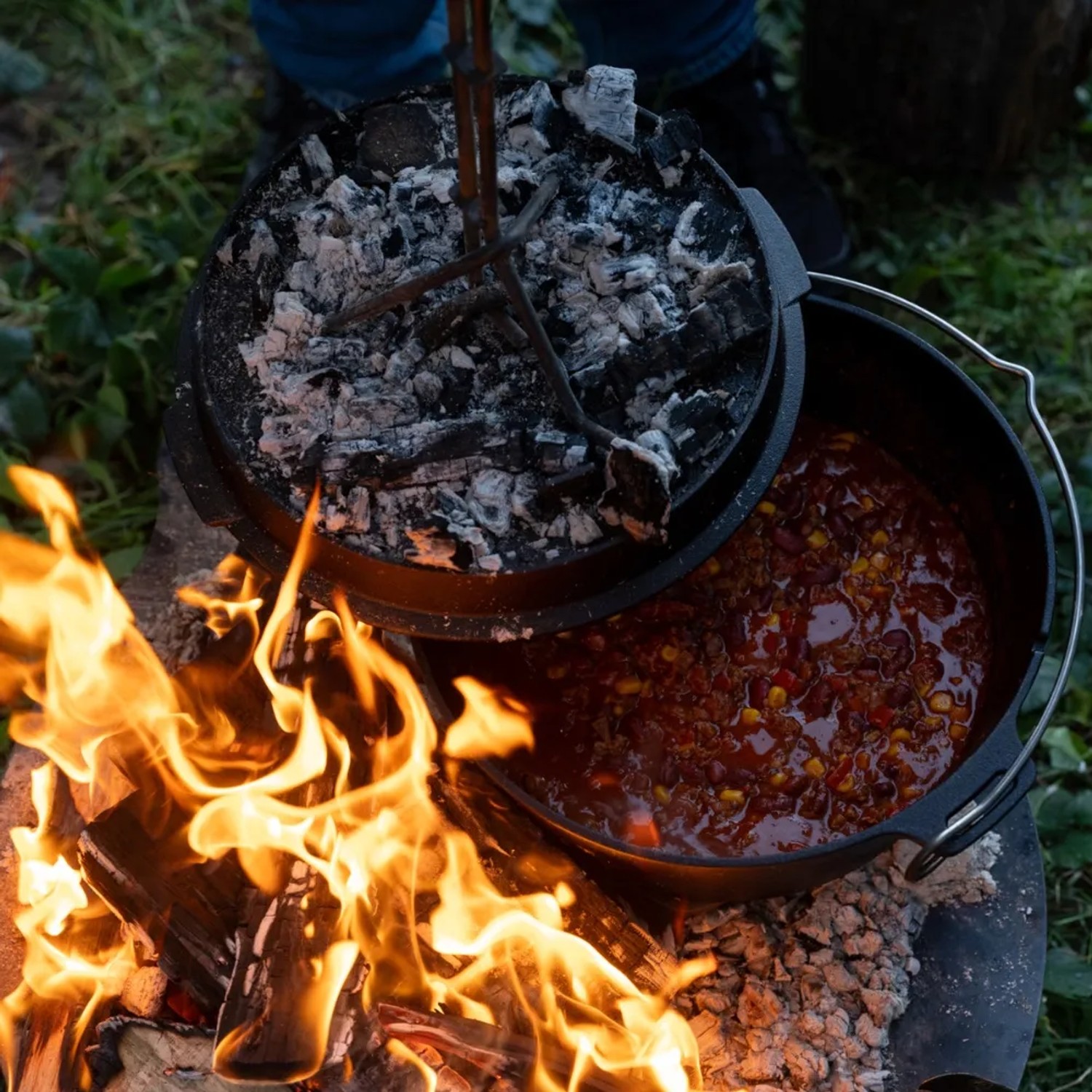 Petromax Dutch Oven FT12: Gusseisen-Topf mit Chili über offenem Feuer. Ideal zum Kochen im Freien.