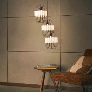 Brilliant Pendelleuchte Slope, 3-flammig, schwarz/natur, über Tisch im Wohnraum.