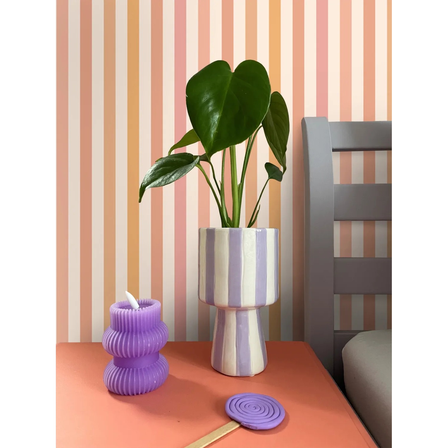 Dekorative Vliestapete mit vertikalen Streifen in Orange, Rosa und hellem Beige. Ideal für moderne Wandgestaltung.