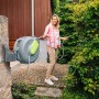 Graue Geka Schlauchbox K25 am Haus mit Frau beim Gießen im Garten.