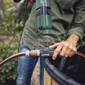 Gardena Bohrmaschinenpumpe im Einsatz mit Bohrmaschine und Schlauch zum Abpumpen von Wasser.
