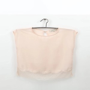 Zartrosa Bluse mit Spitze am Saum auf einem Kleiderbügel.